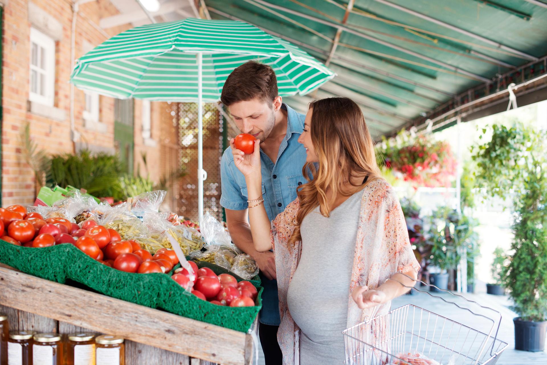 Young couple waiting a baby making grocery at farmer market