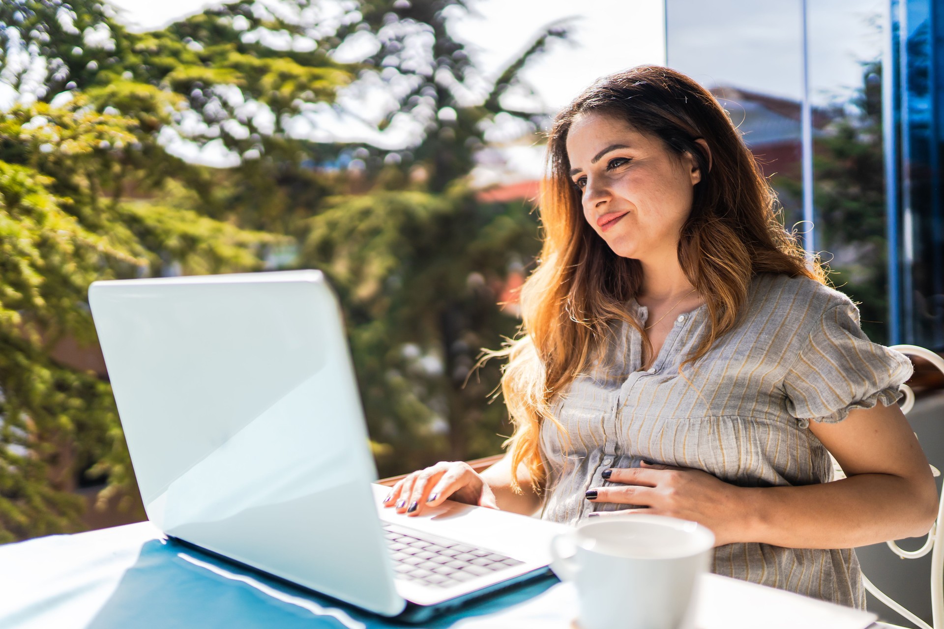 Young woman works from home in the last stages of her pregnancy